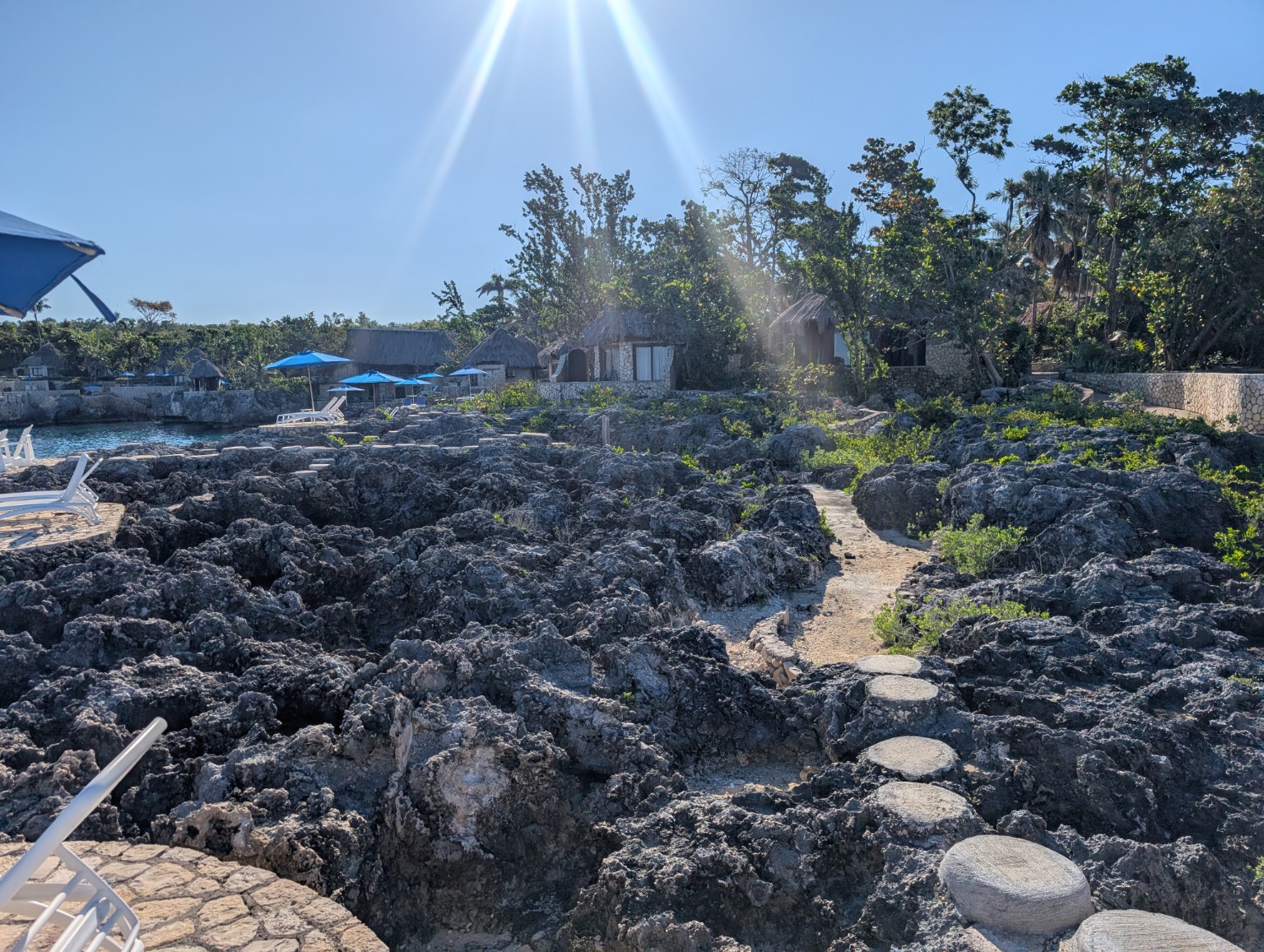 Sunny tropical shoreline with rocky cliffs and cottages
